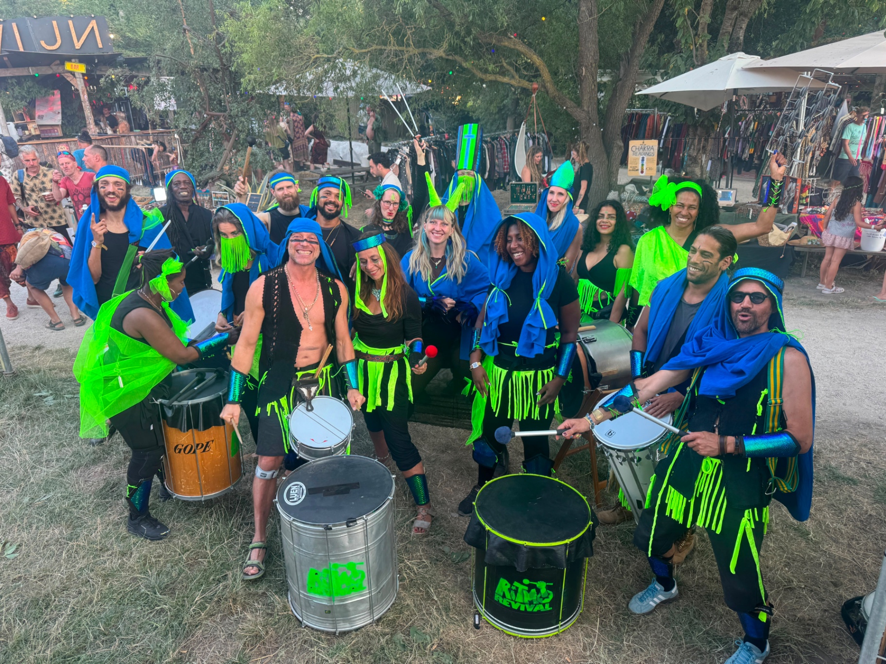 Ritmo Revival members in green and blue costumes with their drums at a festival
