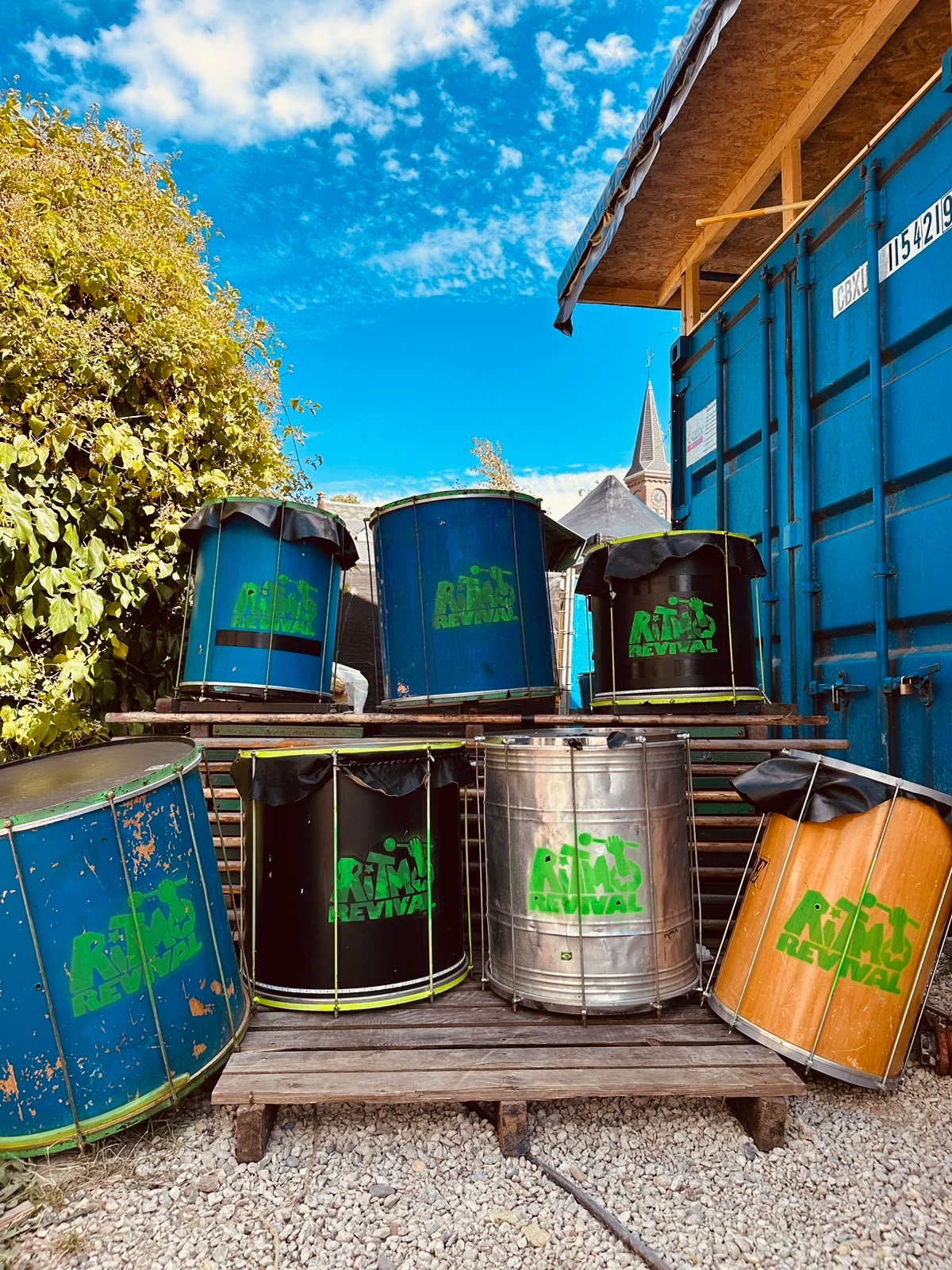 Ritmo Revival surdos and repiniques stacked outside the rehearsal space